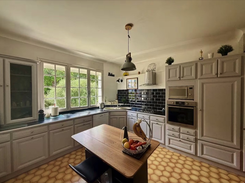 The country kitchen of the split-level Main House, with garden windows and terracotta floor tiles