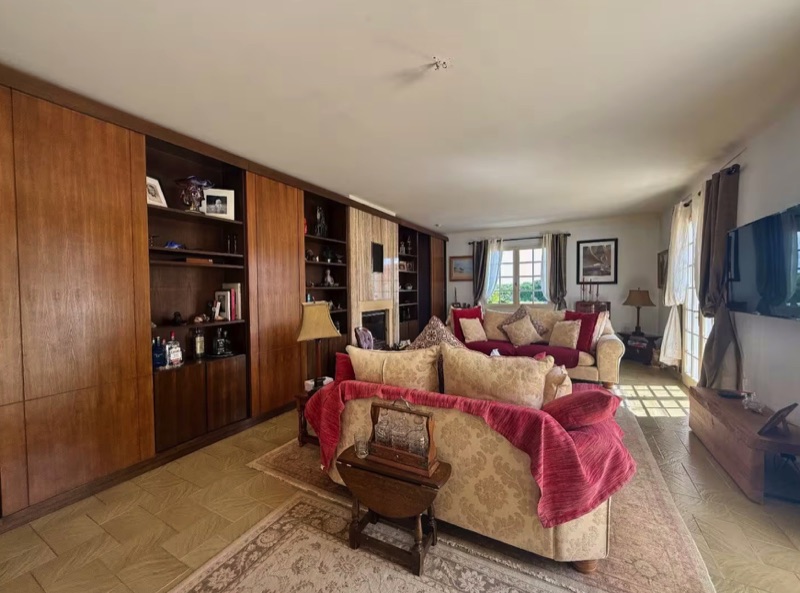 Main House living room with panelled walls and fireplace